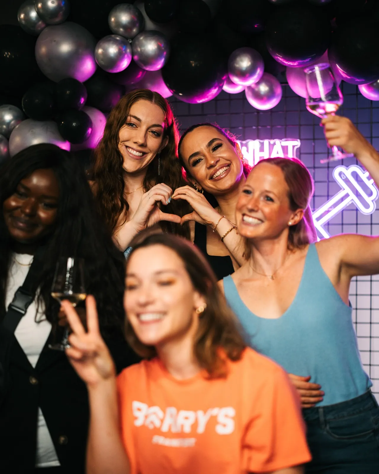 Fünf lachende Frauen posieren auf einer Party vor einem Hintergrund aus Luftballons — Barry’s Frankfurt