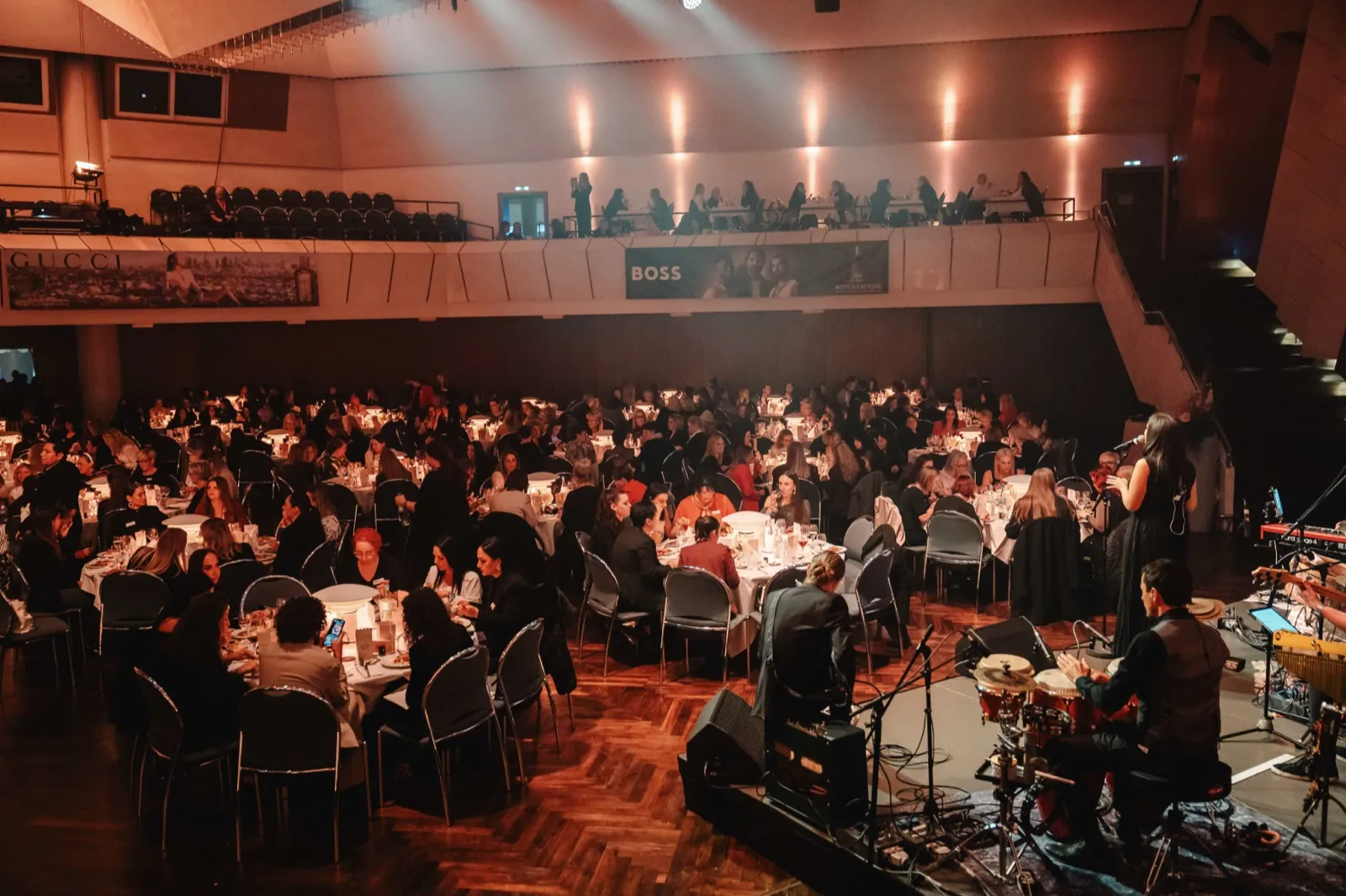 Ein großer Saal mit festlich gedeckten Tischen und einer Live-Band auf der Bühne — Cirque Inspiré im Maritim Hotel Würzburg