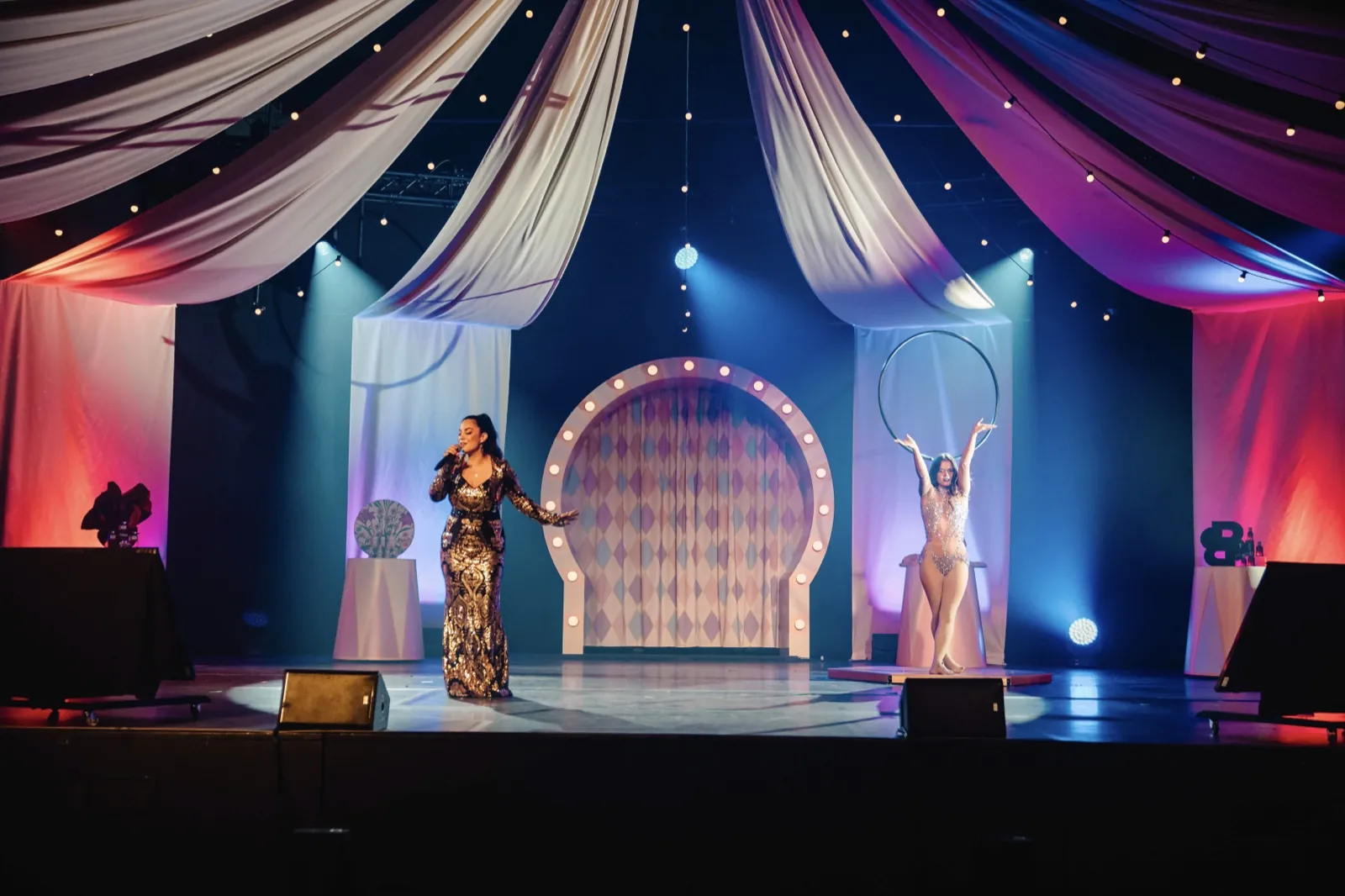 Eine Sängerin und eine Akrobatin treten auf einer festlich beleuchteten Bühne auf — Cirque Inspiré im Maritim Hotel Würzburg
